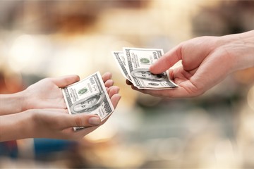 Hands holding one hundred dollars banknote over background