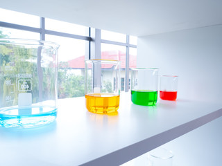 Blue, yellow, green and red fluid acid in flask glassware in scientist lab for experiment research about chemical