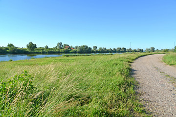 Fototapeta na wymiar View of the dirt road and the Matrosovka River in the neighborhood of the settlement Big Banks. Kaliningrad region