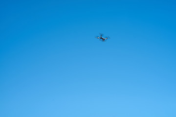 Naklejka na ściany i meble Drone flying in the blue summer sky