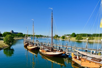 Fototapeta na wymiar Serie of beautiful old wooden sailboats near lock in Veere, Zeeland, Netherlands