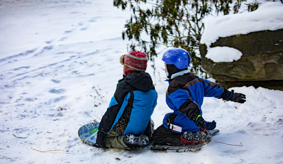 Fototapeta na wymiar Kids sledding in the snow