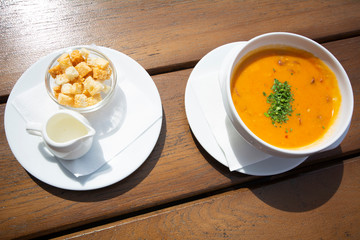 Soup solyanka cooked with meat, sausages, salted cucumbers and olives. Traditional Russian soup on the wooden table.