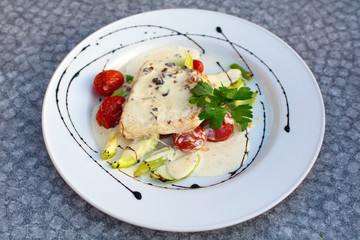 Pike perch fillet with creamy nut sauce with zucchini and grilled tomatoes