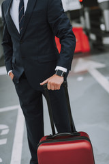 Young guy in black suit waiting in parking lot