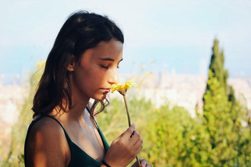 Woman smelling a yellow flower.