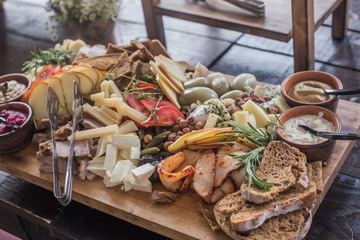 Assorted Ham, Sausage, Mozzarella, Grapefruit, Grapefruit, Date, Basil, Cucumber, Vegetable Grill on a wooden board for a Buffet in a restaurant or event.