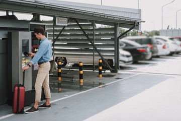 Man making payment with mobile phone in the parking