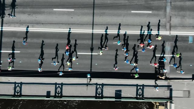 Aerial view of the city marathon, a crowd of people running through the distance, running shadows