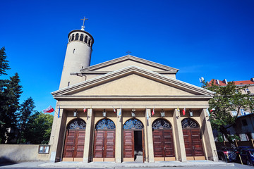 Facade of a historic Roman Catholic church with a belfry in Poznan.