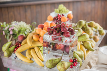 Buffet line assorted Fruit platter of strawberries Raspberry Grapes Blueberries Peaches Apricot Banana Cherry Cherries Pears on ice. View from side