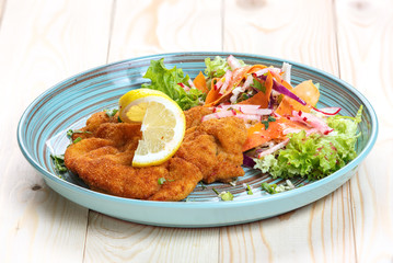 Meat in batter with vegetables on a plate