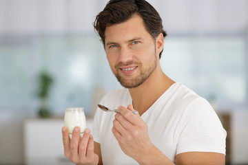 man is eating a yogurt