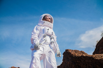 Courageous Astronaut in the Space Suit Explores Red Planet Mars Covered in Mist. Adventure. Space Travel, Habitable World and Colonization Concept © de Art