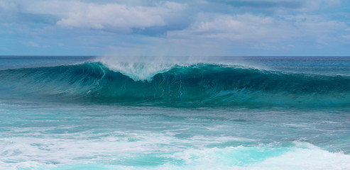 Fototapeta na wymiar Beautiful ocean tube wave rolls towards the beach of an exotic island in Pacific