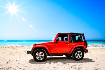 Obraz na płótnie Canvas Summer red car on beach and sea landscape with blue sky and sun . 