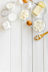 Dairy products from farm with milk, eggs, cottage, butter, yougurt on white wooden background top view mockup