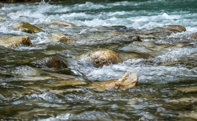Fast mountain stream with rocky shores.