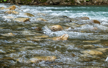 Fast mountain stream with rocky shores.