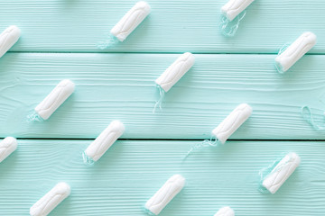 Gynaecologist and menstruation concept with tampons pattern on mint green wooden background top view