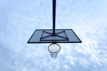 view from below of an outdoors basketball hoop