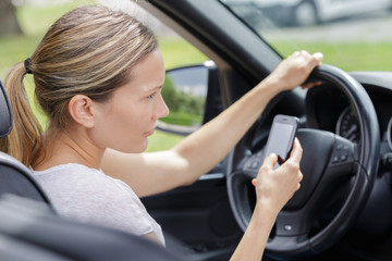 Fototapeta na wymiar woman driver using smart phone in car during driving