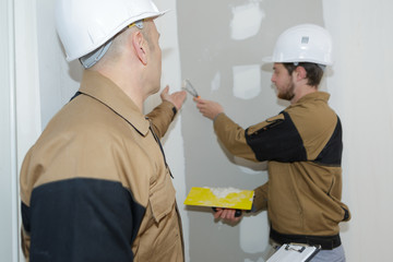 plasterer renovating indoor walls with float and plaster