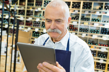 senior sommelier using digital tablet