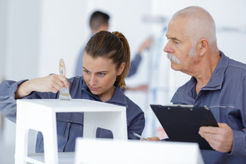 female painting worker painting a furniture