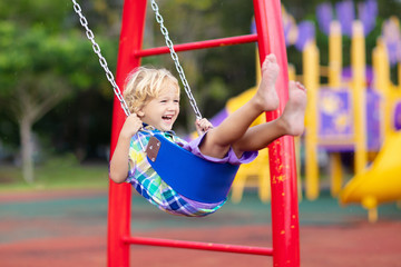 Child on playground. swing Kids play outdoor.