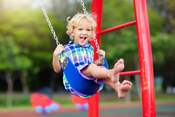 Child on playground. swing Kids play outdoor. - obrazy, fototapety, plakaty