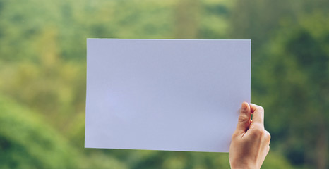 Show business paper in hand on nature background