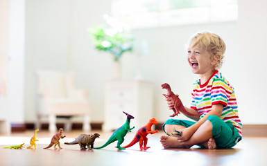 Child playing with toy dinosaurs. Kids toys.