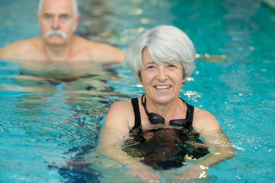 happy active senior woman swimming in pool