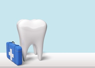 White tooth and dentist blue suitcase on desk
