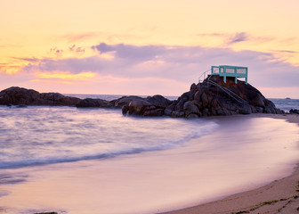 View point or gazebo over the rocks on a beach in Vila do Conde, Portugal, at sunset.