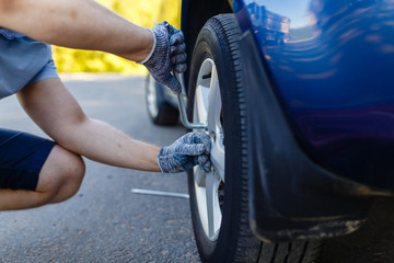 Truck maintenance wheel, Close up of a man unscrew wheel nut of the tire manually, and wheel truck mechanic using jack.