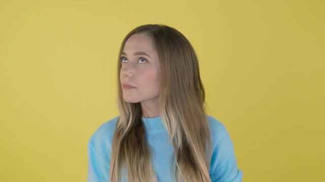 Young beautiful woman casual blue sweater over isolated background smelling something stinky and disgusting, intolerable smell, holding breath with fingers on nose. Bad smells concept 4K