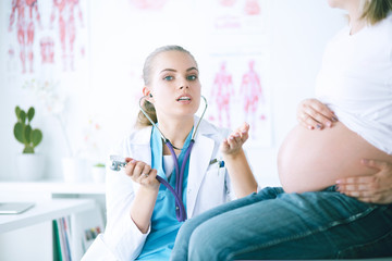 Young female doctor examining pregnant woman at the clinic.