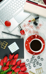 Modern stylish feminine desk or workspace coffee break with high tech touchscreen laptop and red female accessories.