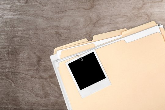 The blank photo on a business folder on wooden table