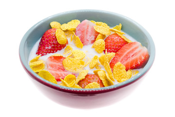 Bowl of cornflakes with milk and strawberries on a white background, isolated