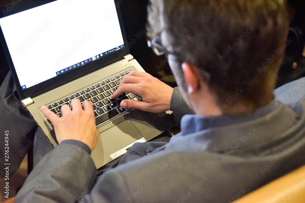 Wall mural valencia, spain - june 20, 2019: journalist takes notes on his laptop from a lecturer's speech.