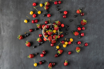 fresh berries of cherry, strawberry and blueberry dropped on the table