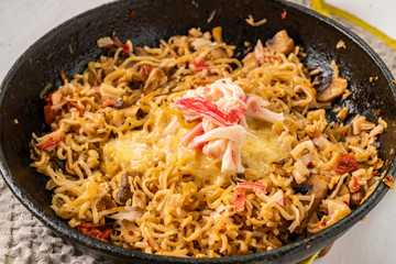 melted cheese in a pan with wpaghetti pasta and seafood top view