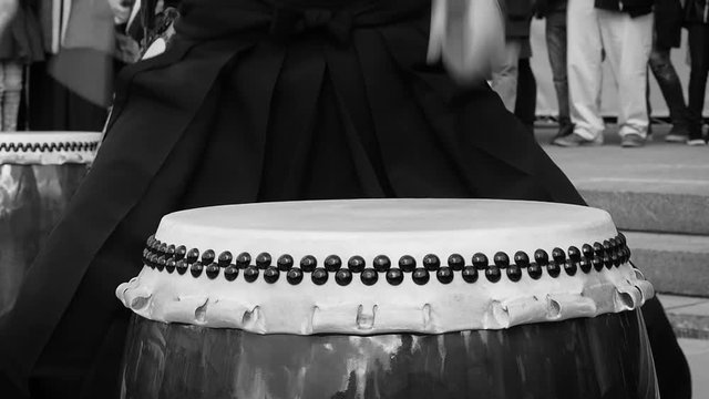 Musicians drummers play taiko drums chu-daiko outdoors. Culture folk music of Asia Korea, Japan, China. In black and white toning