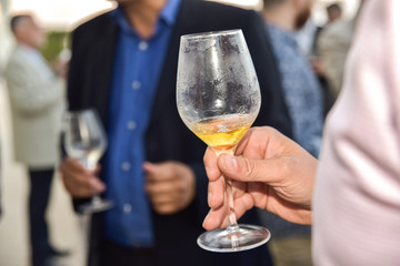 Mature people holding a drink glass during a business reception with unfocused background.