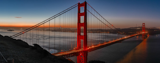 Golden Gate Bridge at sunrise under its lights 