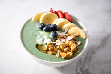 Spirulina yogurt with fruit in wooden bowl