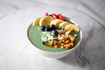 Spirulina yogurt with fruit in wooden bowl